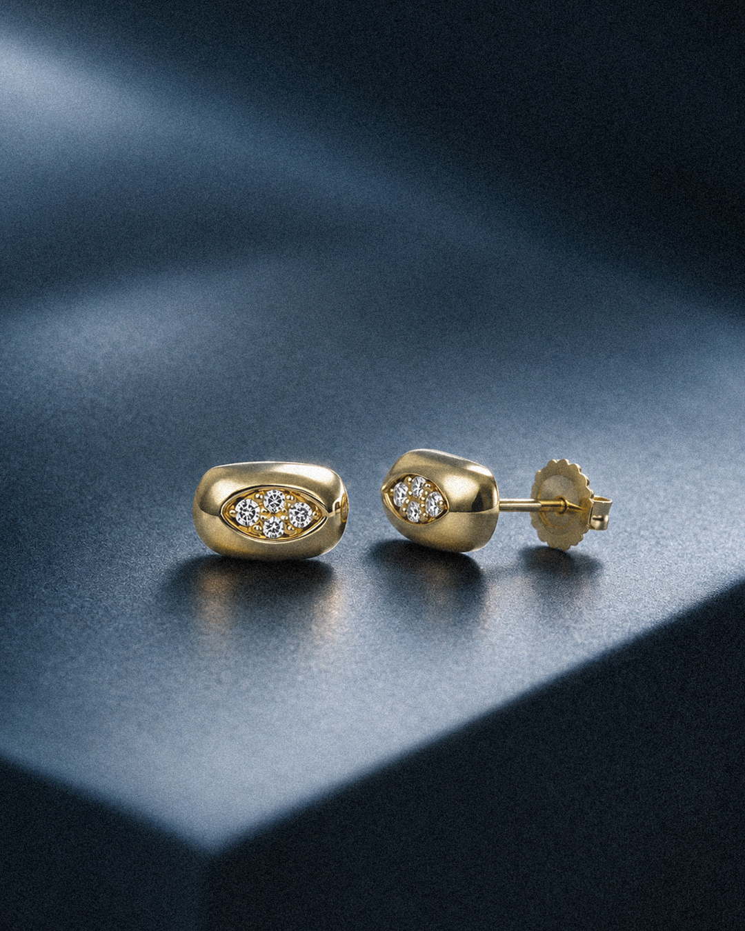 Goldene Ohrstecker mit Zirkonia auf dunklem Grund